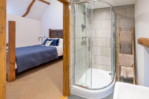 a glass shower in a bedroom with a bed at Hillside Barn in Gimingham