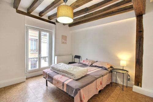 a bedroom with a bed and a large window at Le Franche in Châtillon-sur-Loire