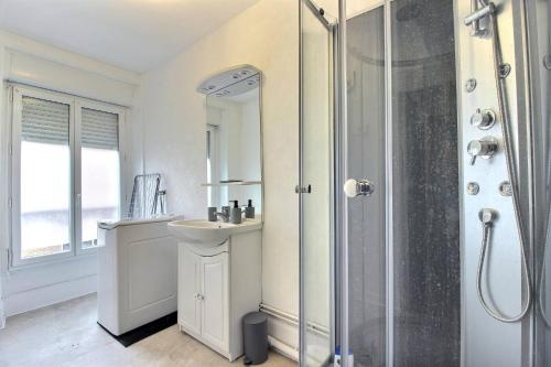 a white bathroom with a sink and a shower at Le Franche in Châtillon-sur-Loire