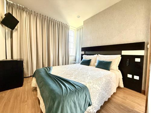 a bedroom with a large bed with blue pillows at Residencial Portas do Sol in Valença