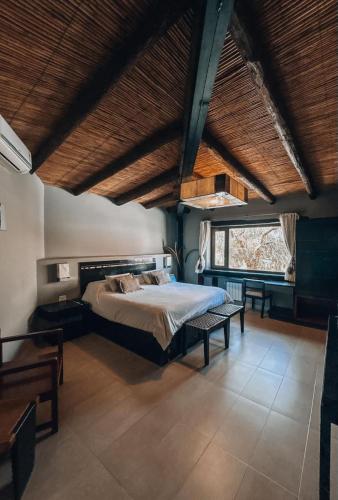 a bedroom with a bed in a room with wooden ceilings at Hostería Terrazas de la Posta in Purmamarca