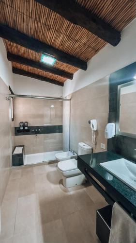 a bathroom with two toilets and a sink and a tub at Hostería Terrazas de la Posta in Purmamarca