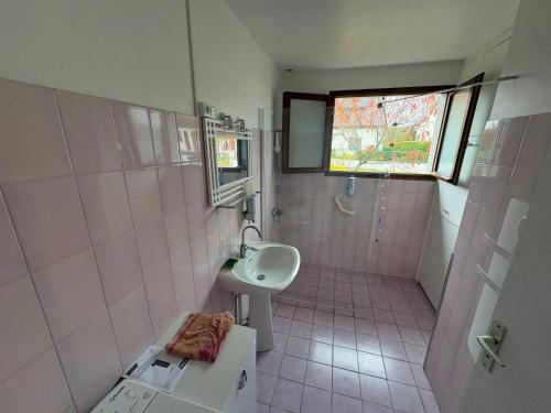 a pink bathroom with a sink and a shower at Le Petit Puits de l Ange in Bonny-sur-Loire