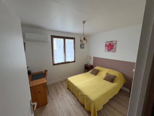 a bedroom with a yellow bed and a window at Le Petit Puits de l Ange in Bonny-sur-Loire