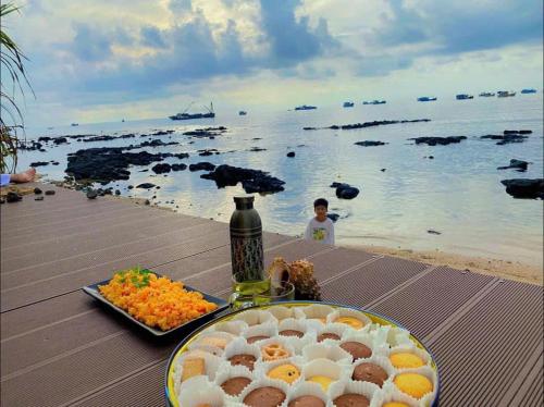 a table with a plate of food on the beach at Villa - Homestay Giác in Cu Lao Thu
