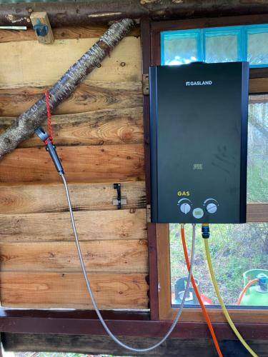 a television on the wall of a log cabin at Sapphire forest garden shepherd’s hut in Church Stretton