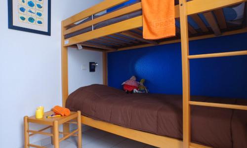 a bedroom with a bunk bed and a blue wall at VVF Sigean Port-la-Nouvelle Corbières in Sigean