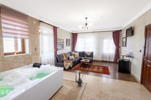 a living room with a tub and a couch at Yellow Stone House in Göreme