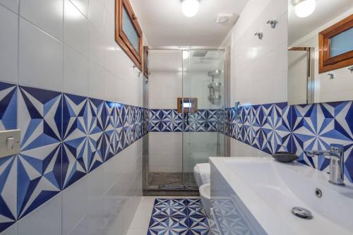 a bathroom with blue and white tiled walls and a shower at A casa di Gennarino in Cetara
