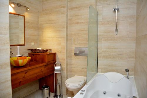 a bathroom with a tub and a toilet and a sink at Momini Dvori Boutique Guest House in Bansko