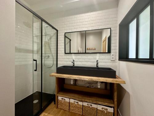 a bathroom with a black sink and a mirror at La Forge 8 Personnes in Bèze