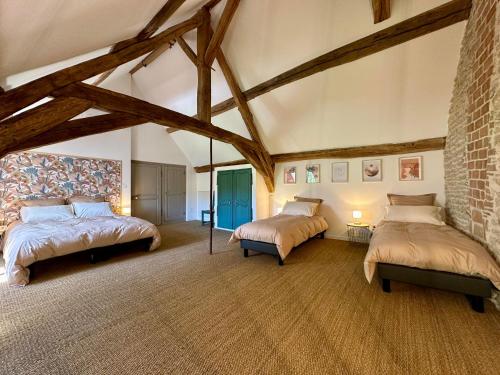 a bedroom with two beds and a brick wall at La Forge 8 Personnes in Bèze