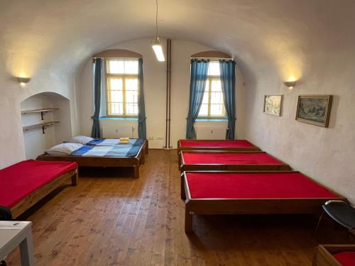 a room with three beds and two windows at Artillery Barracks Accommodation in Terezín