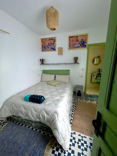 a bedroom with a bed with a white comforter at Surf house in Essaouira