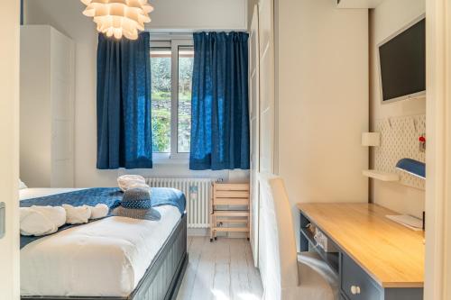 a bedroom with a bed with blue curtains and a desk at Casa Concetta in Rapallo
