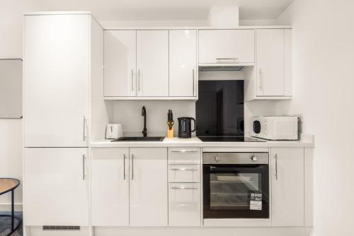 a white kitchen with white cabinets and appliances at Stylish 1 BED Apartment in Central Hull in Hull