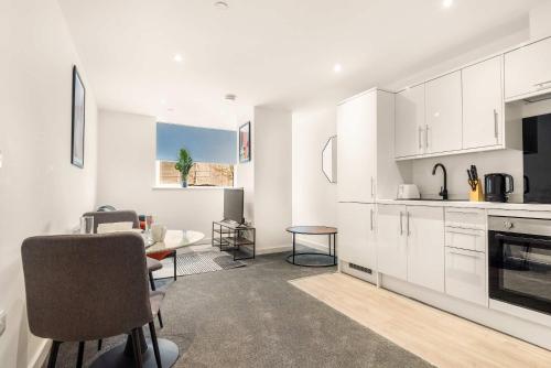 a kitchen with white cabinets and a table and chairs at Stylish 1 BED Apartment in Central Hull in Hull