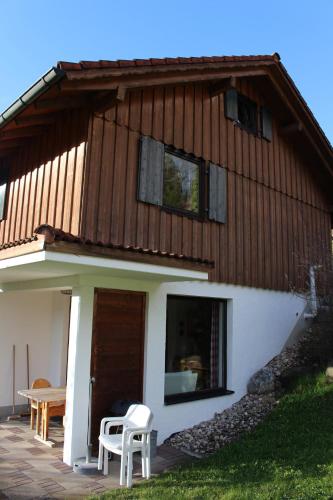 a house with two chairs and a table in front of it at Ferienhaus Alpkönigin in Missen-Wilhams