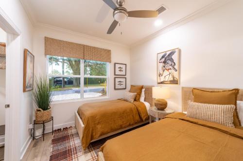 a bedroom with two beds and a window at Palmetto Place, Charming Saint Simons Bungalow in Saint Simons Island