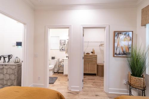 a bedroom with a bed and a bathroom at Palmetto Place, Charming Saint Simons Bungalow in Saint Simons Island