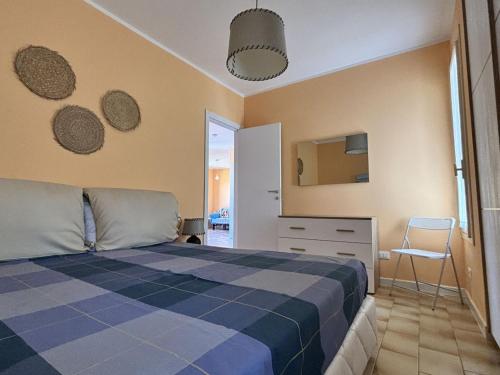 a bedroom with a bed and a chair in it at Capo d 'Arco - Agrumeto in Capo D'Arco
