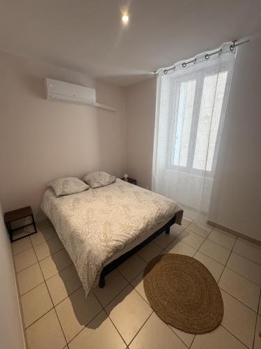 a bedroom with a bed and a window and a rug at Le Mercoyrol in Cruas