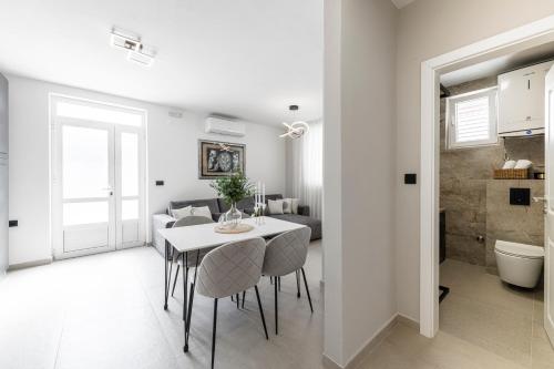 a kitchen and living room with a table and chairs at Cozy Corner 49 in Cavtat