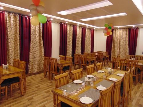 a banquet hall with tables and chairs and balloons at Hotel Dewan Palace in Dharmsāla