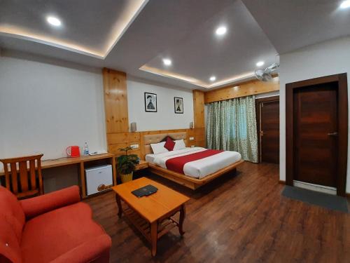 a hotel room with a bed and a couch and a table at Hotel Dewan Palace in Dharmsāla