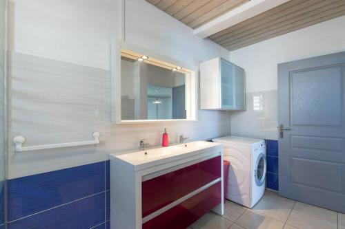 a bathroom with a sink and a washing machine at L' Amandava in Petite Île