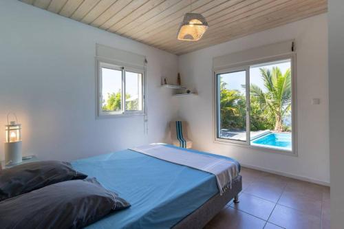 a bedroom with a bed with a view of a pool at L' Amandava in Petite Île