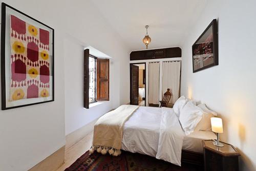 Riad Porte Royale في مراكش: غرفة نوم بسرير ابيض ومرآتين
