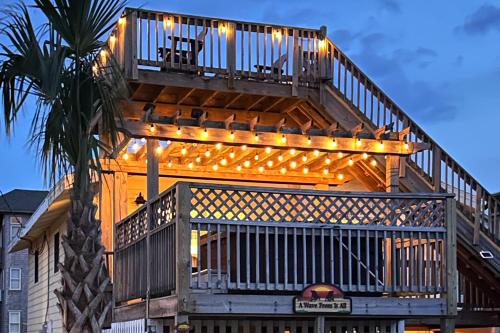 a building with a deck with lights on it at 7039 - A Wave From It All in Rodanthe