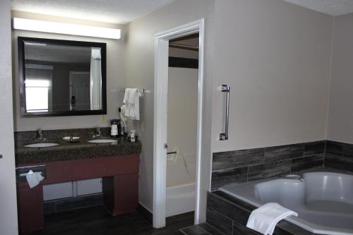 a bathroom with a tub and a sink and a bath tub at Super 8 by Wyndham Fort Chiswell Wytheville Area in Max Meadows