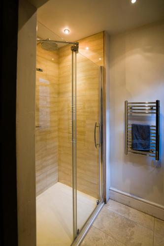 a shower with a glass door in a bathroom at The Old House Apartment in Shrewsbury
