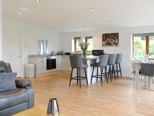 a kitchen and living room with a table and chairs at Kimberdale Lodge in Great Orton