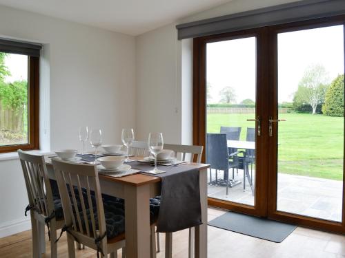 a dining room with a table with wine glasses at Kimberdale Lodge in Great Orton