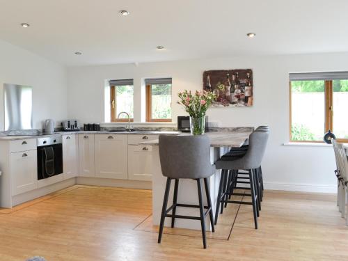 a kitchen with a table and some chairs in a room at Kimberdale Lodge in Great Orton