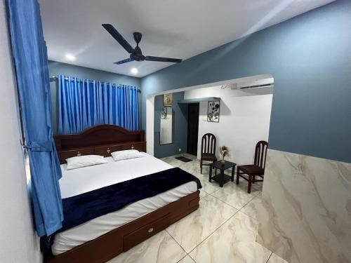 a bedroom with a bed and a ceiling fan at Nandbhavan Guruvayur in Guruvāyūr