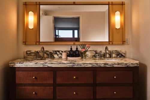 a bathroom counter with a sink and a mirror at Dune House Hotel & Spa in Atlantic Beach