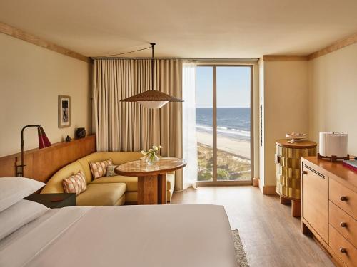a hotel room with a bed and a view of the ocean at Dune House Hotel & Spa in Atlantic Beach