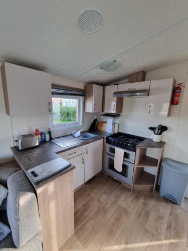 a kitchen with a sink and a stove top oven at Swanage Caravan in Swanage