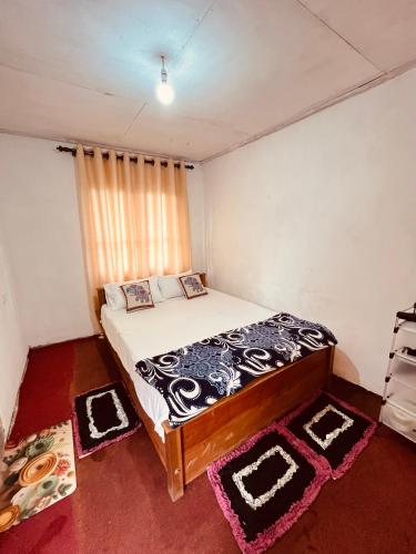 a bedroom with a bed and a window with rugs at Cinderella three arch view in Ella