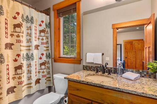a bathroom with a sink and a toilet and a shower curtain at Monabel Manor in Cle Elum