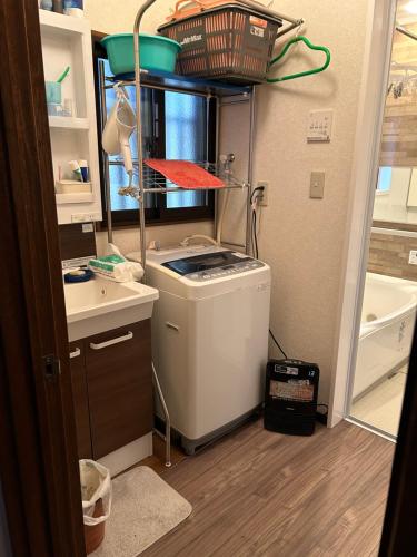 a small kitchen with a sink and a washing machine at 艶子の家 in Narashino