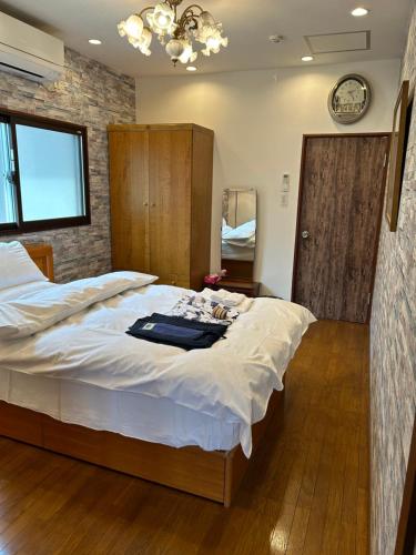 a bedroom with a large bed and a clock on the wall at 艶子の家 in Narashino
