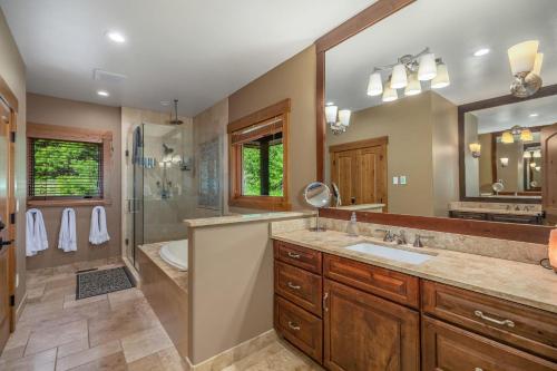 a bathroom with two sinks and a shower and a mirror at Grand Manifest Lodge in Ronald