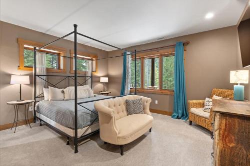 a bedroom with a four poster bed and a chair at Grand Manifest Lodge in Ronald