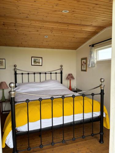 a bed in a bedroom with a wooden ceiling at Swedish Rustic Cabin perfect for bird watching in Emsworth
