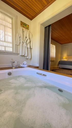 a large bath tub in a room with a mirror at Pousada Do Conde in Campos do Jordão